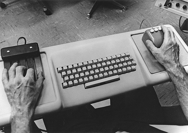 Hands on an early computer keyboard and chorded keyset from Douglas Engelbart’s 1968 demo
